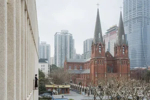 A photograph depicting an urban church with modern skyscrapers in the background.