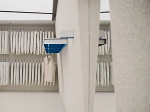 White cloth hangers arranged neatly on a wall-mounted rack.