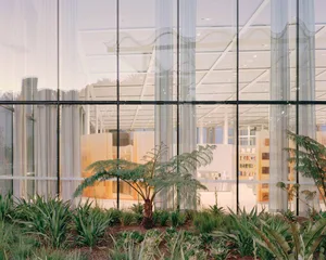 A minimalist interior with glass walls and concrete flooring.