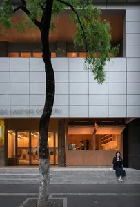 Modern retail storefront with concrete exterior and warm interior lighting.