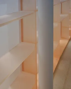A minimalist bookshelf constructed from clear acrylic panels.