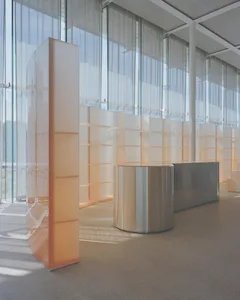 A minimalist office interior with large glass windows and open space.
