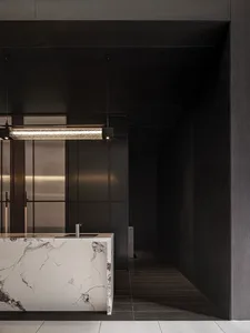 Modern kitchen featuring marble countertops and sleek black cabinetry.