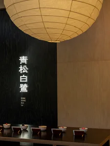 現代餐廳室內，木質牆面搭配大型紙燈懸掛於上方。