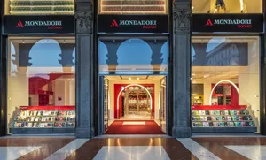 Modern storefront with glass windows, concrete accents, and illuminated signage.