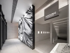 Modern, minimalist medical clinic with a metal-clad wall, illuminated by recessed lighting and featuring marble flooring.