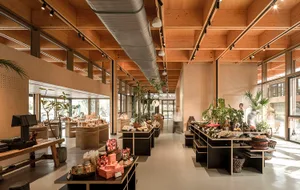 現代零售空間採用木質室內設計，搭配植物與各式待售商品。