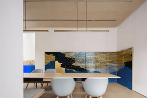 Modern office setting with a meeting room featuring wood paneling on the walls and a wooden table with grey upholstered moder