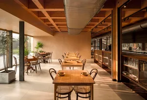 A modern restaurant interior featuring sustainable wood and glass materials.