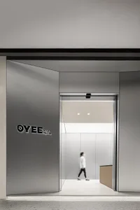 A minimalist retail storefront with a modern design, featuring a metal facade and an open interior.