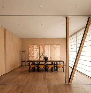 Modern dining room with a wooden table and chairs, featuring a minimalist design aesthetic.