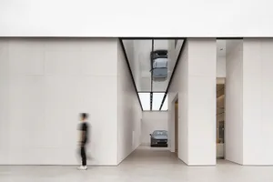 A modern car showroom featuring sleek, minimalist design with glass and concrete materials.