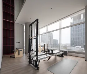 A well-lit, modern health club featuring wooden exercise machines with large windows overlooking the city.