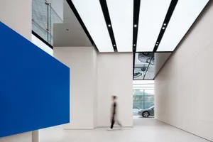 Modern car dealership interior with white and blue accent wall