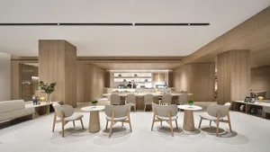 A modern indoor seating area with wooden furniture and tables in a well-lit coffee shop.