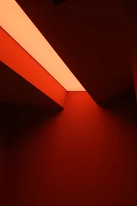 An interior space illuminated by a red light fixture creating a dramatic and modern ambiance.