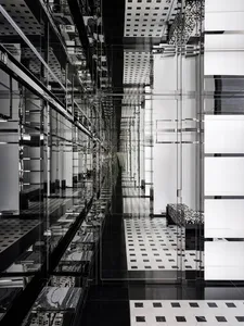 Modern commercial interior designed with minimalist aesthetics, featuring glass walls, stone accents, and mirrored surfaces.