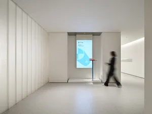 A minimalist interior design with a digital display showing a congratulatory message, illuminated by white lighting and featu