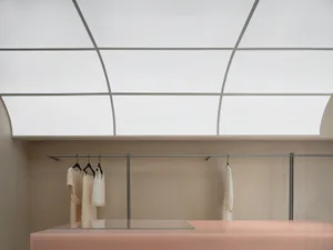 A modern minimalist fashion retail space features concrete and glass materials.
