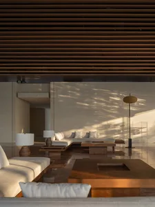 A modern minimalist living room with wood furniture and floor-to-ceiling windows.