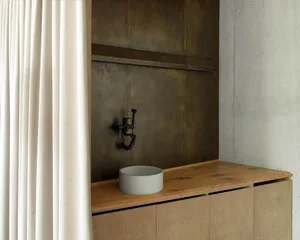 Modern minimalist bathroom featuring concrete sink and wooden vanity.
