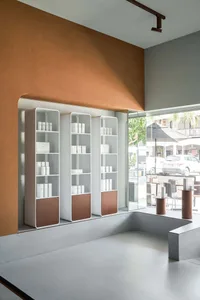 Minimalist retail storefront with concrete walls and glass display shelves.