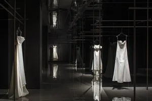 Modern minimalist clothing display featuring sleek metal railings and glass fixtures.