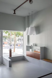 Modern minimalist retail storefront featuring concrete materials and simple design elements.
