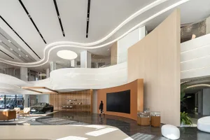 A modern automotive showroom featuring sleek design elements such as marble, glass, metal, and wood.