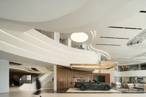 現代汽車展示間室內，搭配木質元素、玻璃牆，以及一輛綠色展示車。