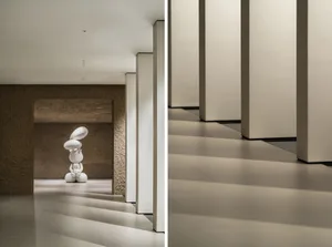 A modern interior space featuring a white concrete sculpture with abstract shapes.