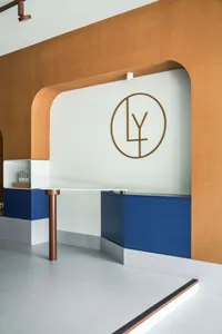 A modern reception desk with a concrete tabletop and blue cabinets.