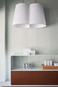 A minimalist storefront featuring white walls and a white shelving unit with products.