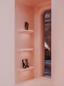 A minimalist concrete shelving unit with decorative items in a cozy alcove.