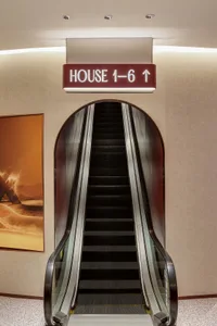 An illuminated escalator system with industrial lighting in a modern commercial interior.