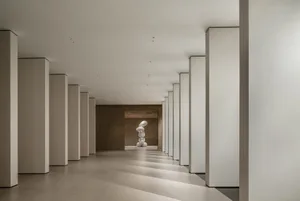 Modern interior design featuring white columns and concrete walls.