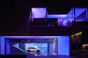 A modern retail storefront with a glass exterior at night.
