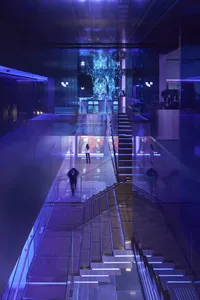 People walking through a modern glass museum exhibition hall with blue lighting