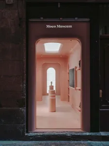 A minimalist museum interior with pastel-colored walls and a skylight.