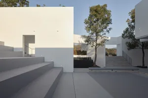 Minimalist modern building with concrete construction and geometric design elements.