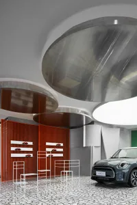 A sleek, modern automotive showroom featuring metallic shelves and a grey car on display
