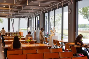 People sitting at wooden tables in a modern cafe