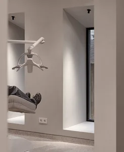 A modern medical treatment room with minimalist design and natural light.