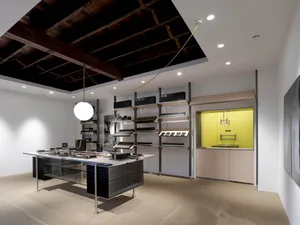 A modern retail storefront with black metal accents and concrete flooring.