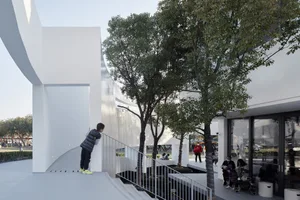 Modern public space with glass walls and metallic railings.