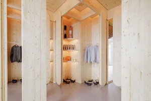 A minimalist clothing store interior featuring natural wood walls and steel accents.