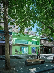 A minimalist retail storefront with a glass exterior and green accents.