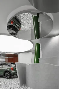 A modern car dealership with concrete walls and an innovative ceiling design.