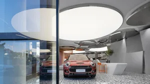 Modern car dealership showroom with glass walls and concrete flooring.