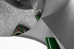 Concrete car park ceiling with geometric shapes and a green car parked below.